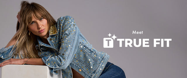 Woman wearing a denim jacket with 'True Fit' logo on a gray background