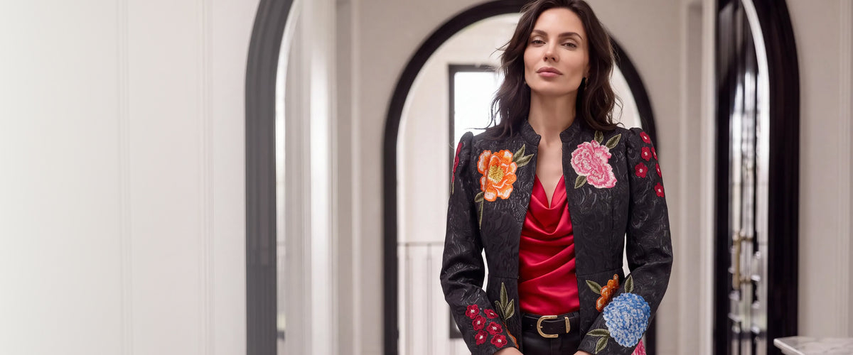 Models wearing a black and embroidered jacket with a red Marilyn top.