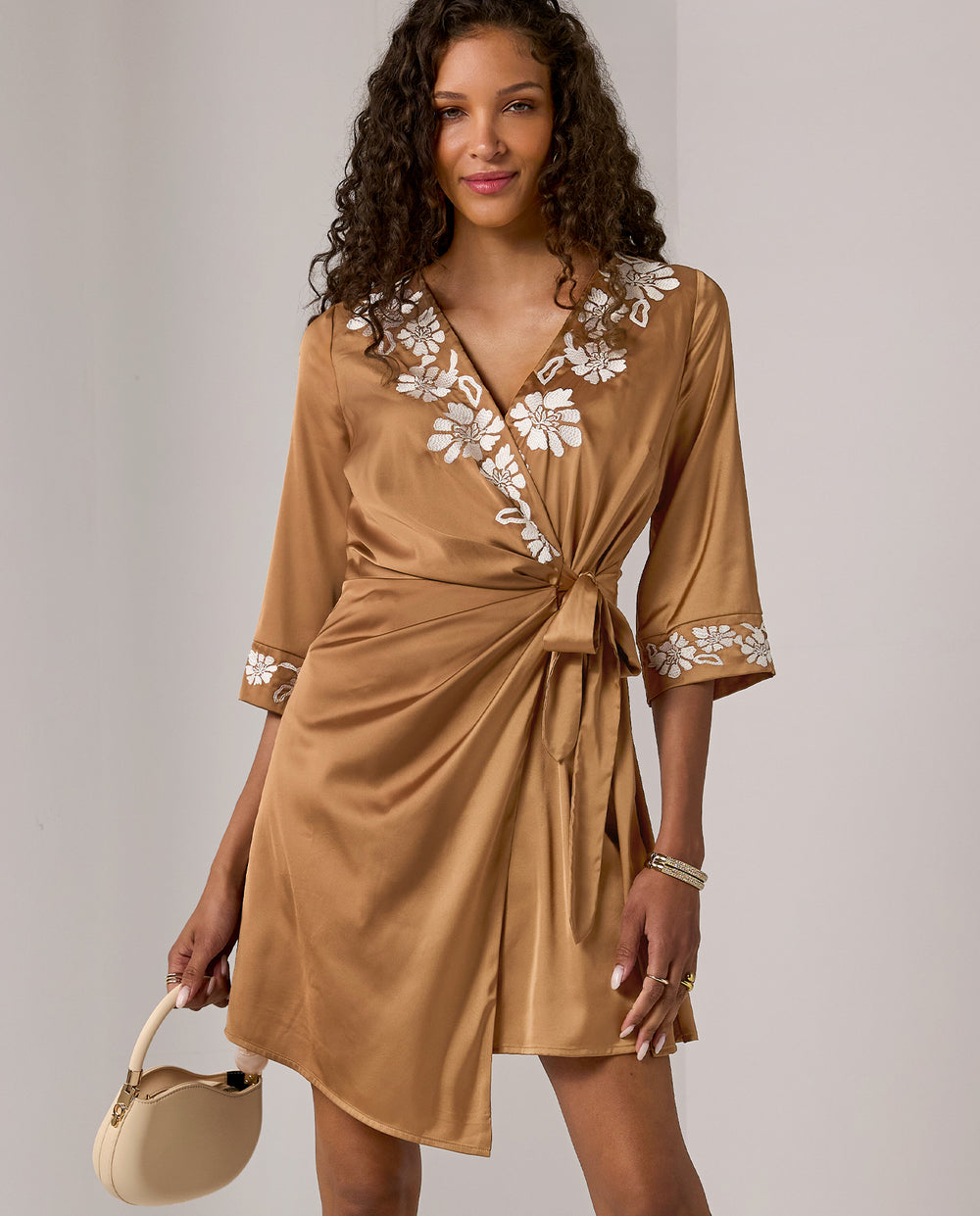models wearing tan and white floral wrap short dress
