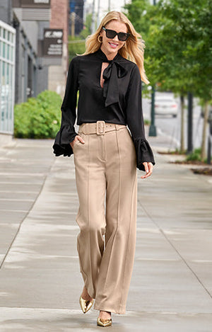 Model wearing black blouse and tan malibu palazzo pants.