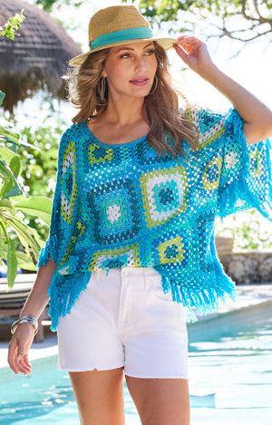 Models wearing crochet blue mutli top with white jean shorts and hat.