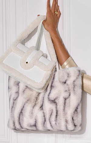 models holding new faux fur bags