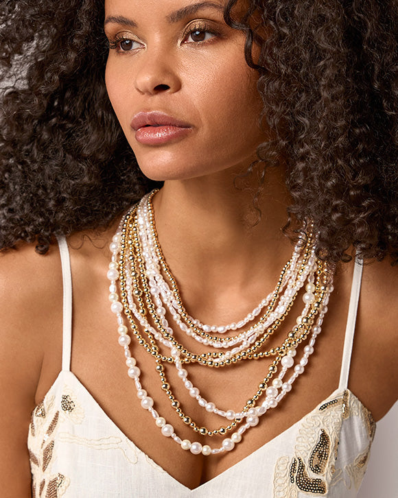 models wearing gold and pearl layered necklace
