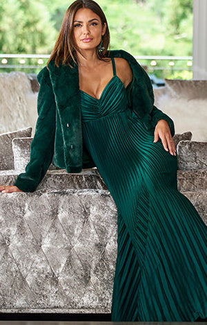 Model in floor length emerald, green dress with plush emerald, green jacket.