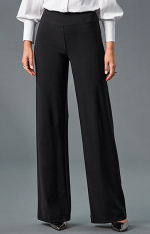 Model wearing victoria white blouse, black beyond travel palazzo pants and metallic black heels.